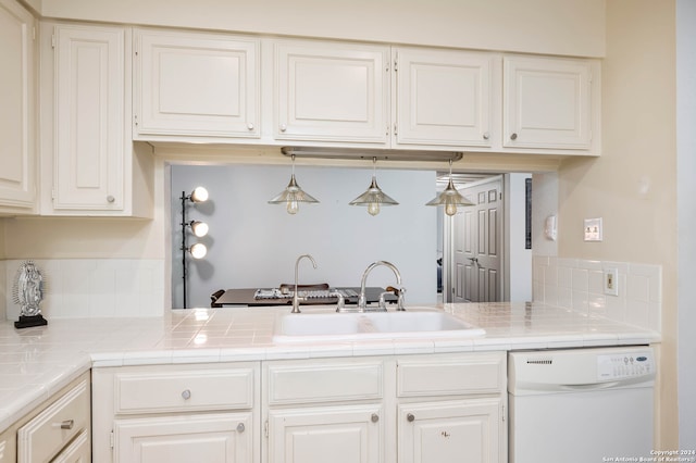 kitchen featuring white cabinets, sink, tile counters, dishwasher, and hanging light fixtures