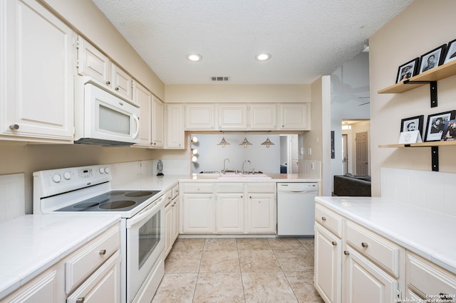 kitchen featuring a textured ceiling, white cabinetry, sink, and white appliances