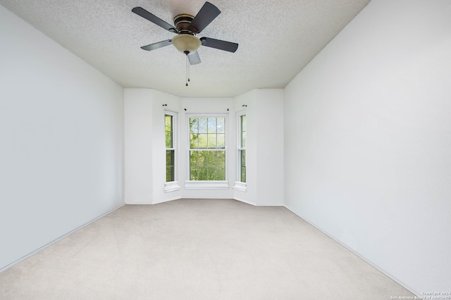 carpeted empty room with a textured ceiling and ceiling fan