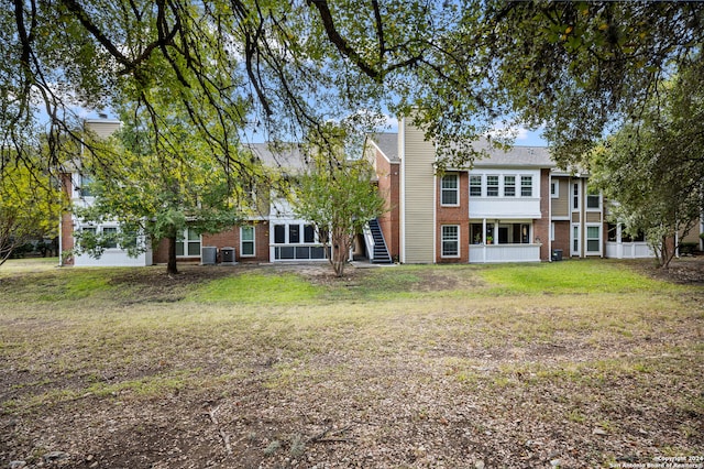 back of house featuring central AC and a lawn