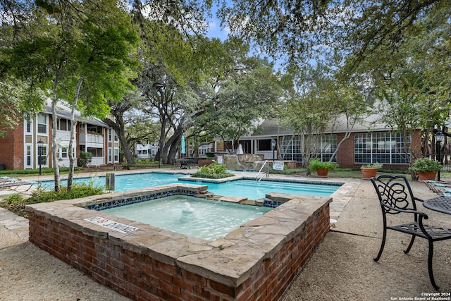 view of swimming pool with a community hot tub