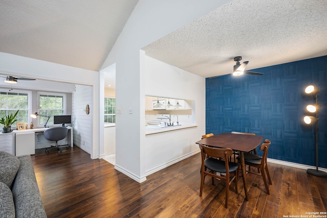 dining space featuring a textured ceiling, ceiling fan, sink, dark hardwood / wood-style floors, and lofted ceiling