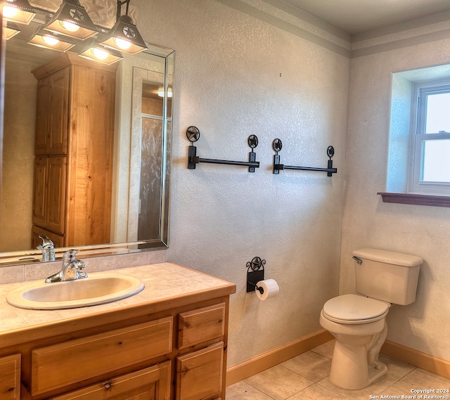 bathroom with tile patterned floors, a shower, vanity, and toilet