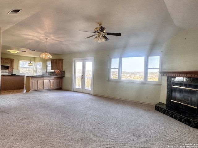 unfurnished living room with french doors, a fireplace, carpet floors, and vaulted ceiling