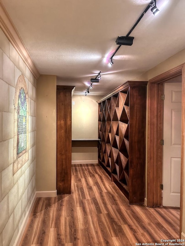 interior space with hardwood / wood-style floors, a textured ceiling, and ornamental molding