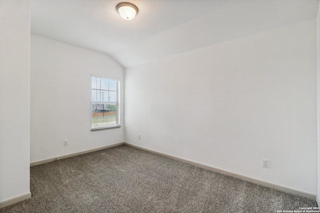 empty room with carpet flooring and lofted ceiling