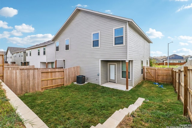 rear view of house featuring a patio, central AC unit, and a lawn