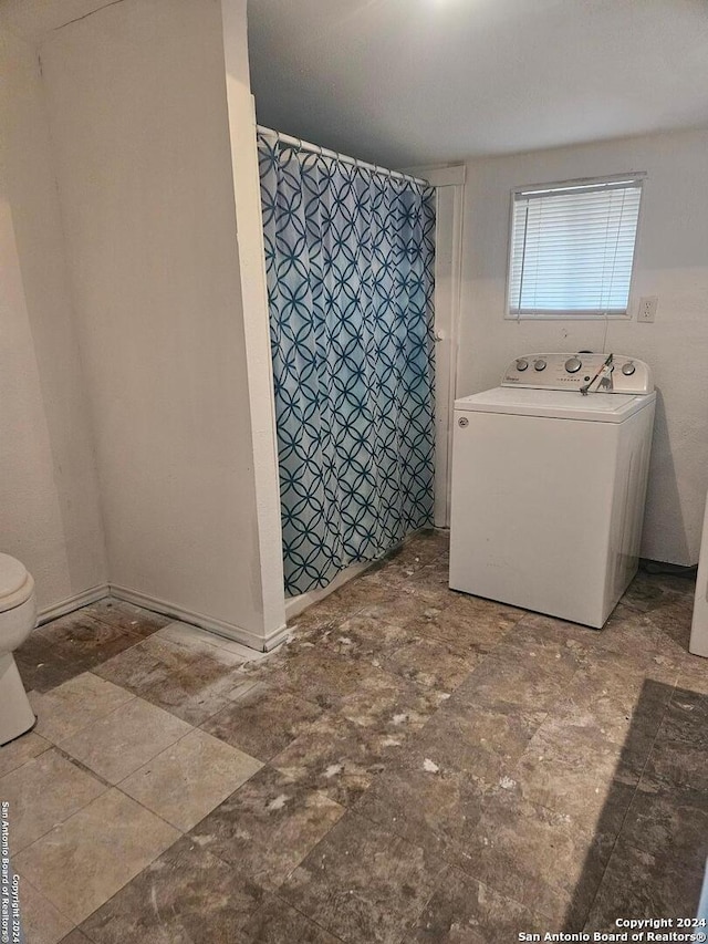 bathroom featuring toilet and washer / dryer