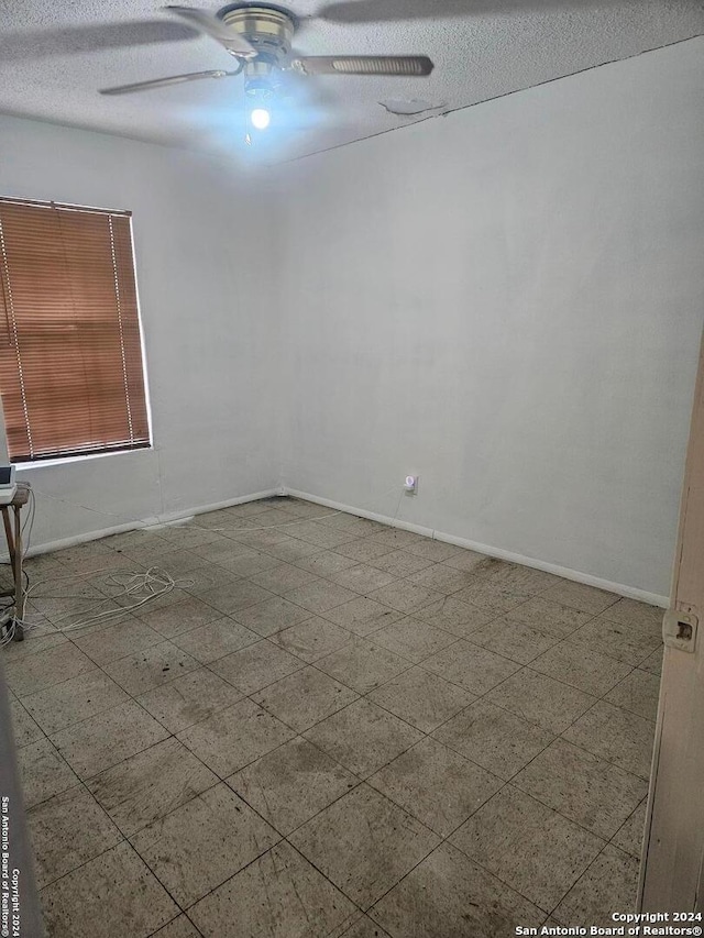 unfurnished room featuring ceiling fan and a textured ceiling