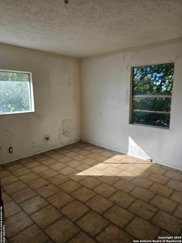 spare room with a textured ceiling