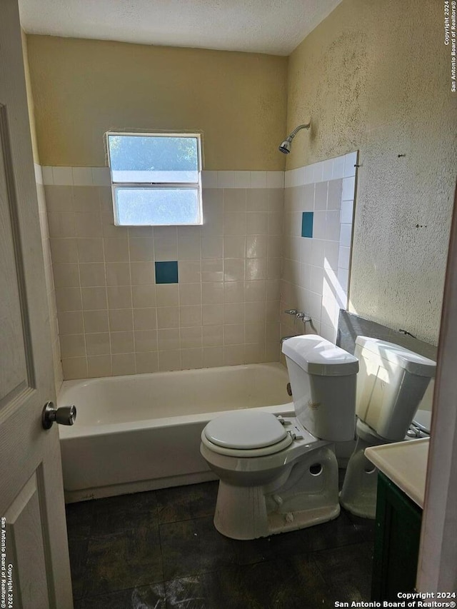 full bathroom featuring toilet, tiled shower / bath combo, and vanity