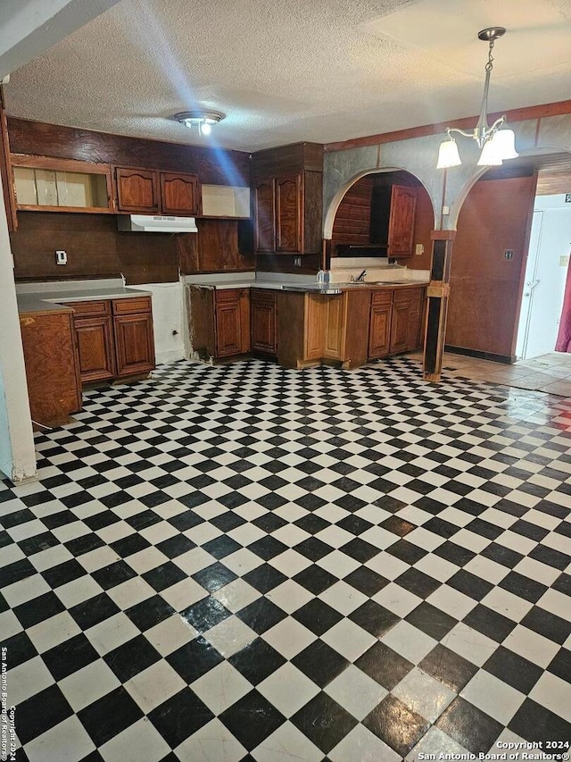 kitchen featuring a textured ceiling and pendant lighting