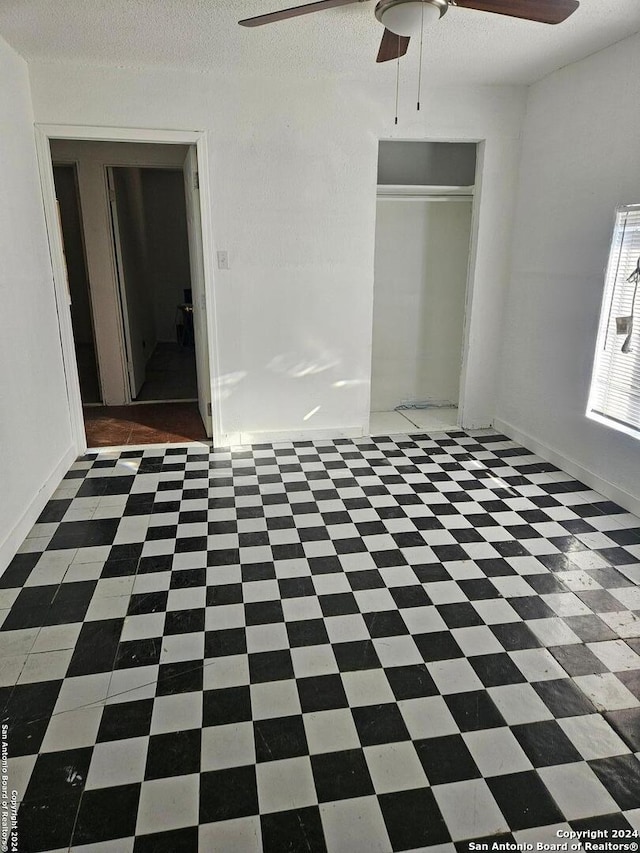 unfurnished bedroom featuring a textured ceiling, a closet, and ceiling fan