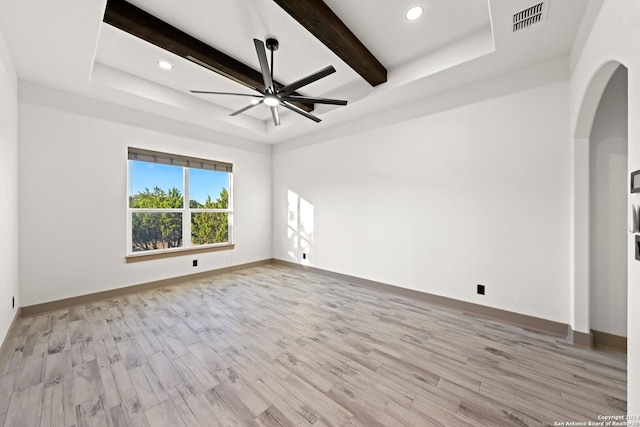 empty room featuring beam ceiling, light hardwood / wood-style flooring, and ceiling fan