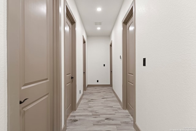 hallway with light hardwood / wood-style floors