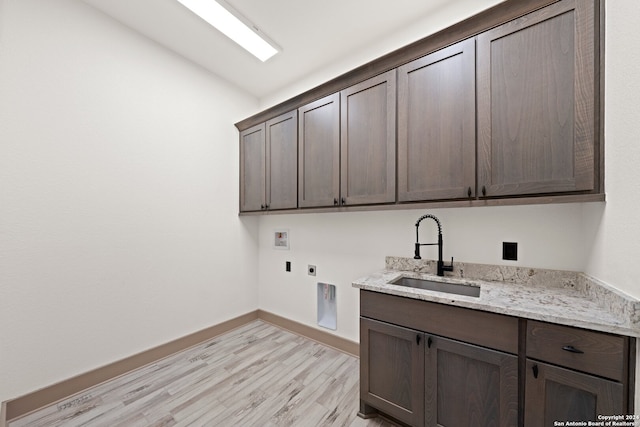 laundry room featuring electric dryer hookup, cabinets, sink, washer hookup, and light hardwood / wood-style floors