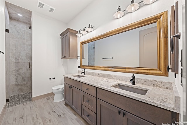 bathroom featuring hardwood / wood-style floors, vanity, toilet, and an enclosed shower