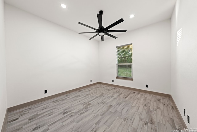 empty room with ceiling fan and light hardwood / wood-style flooring