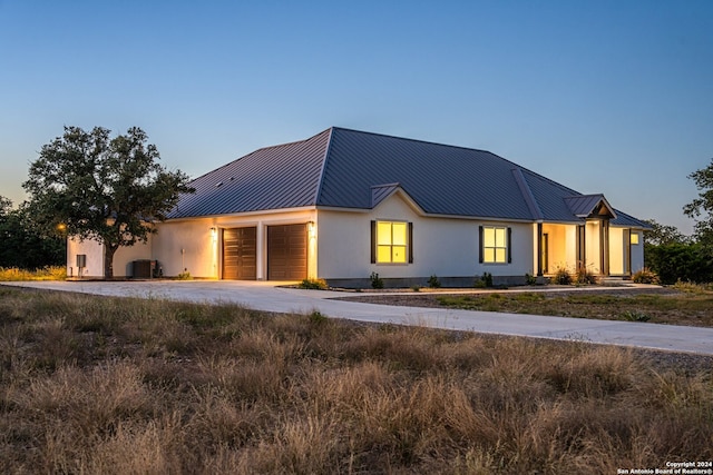 modern farmhouse style home featuring central AC unit and a garage