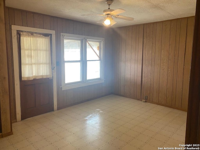 empty room with wooden walls and ceiling fan