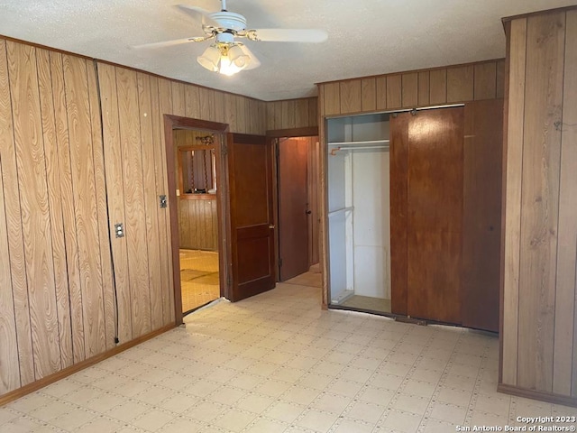 17770 Interstate 35, Lytle, TX 78052 - unfurnished bedroom with light flooring, wooden walls, a closet, and a ceiling fan