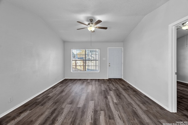 unfurnished room featuring a textured ceiling, ceiling fan, dark hardwood / wood-style floors, and lofted ceiling