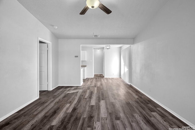 unfurnished living room with a textured ceiling, ceiling fan, and dark wood-type flooring