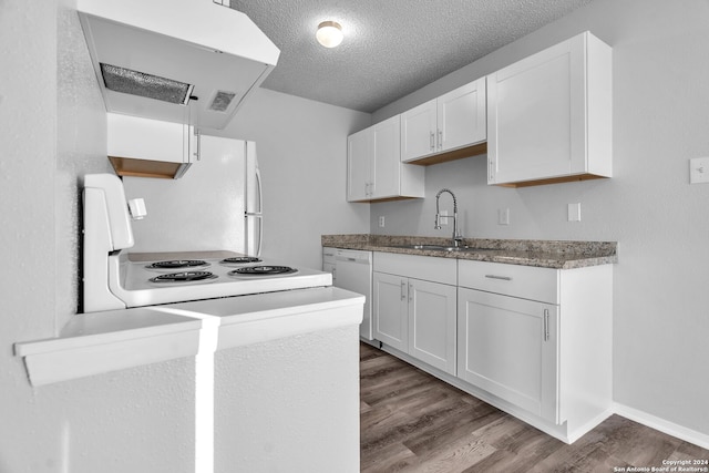 kitchen with white appliances, exhaust hood, white cabinets, sink, and hardwood / wood-style flooring