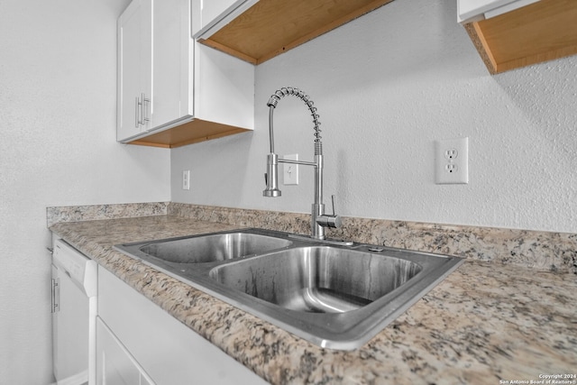 kitchen featuring dishwasher, white cabinetry, and sink