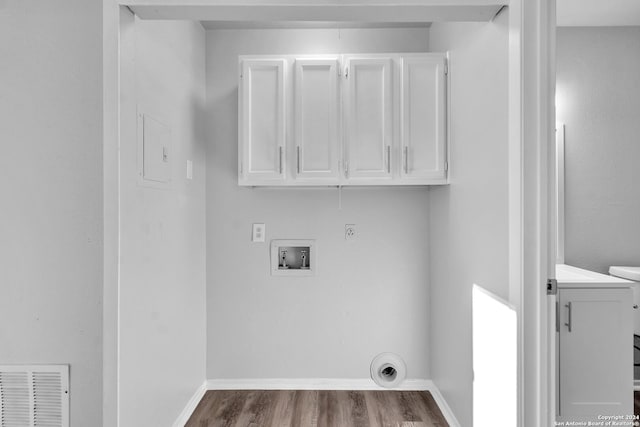 laundry room with cabinets, wood-type flooring, gas dryer hookup, and washer hookup