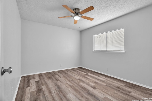 spare room with ceiling fan, wood-type flooring, and a textured ceiling