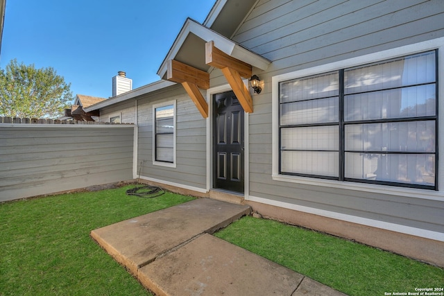 doorway to property with a yard