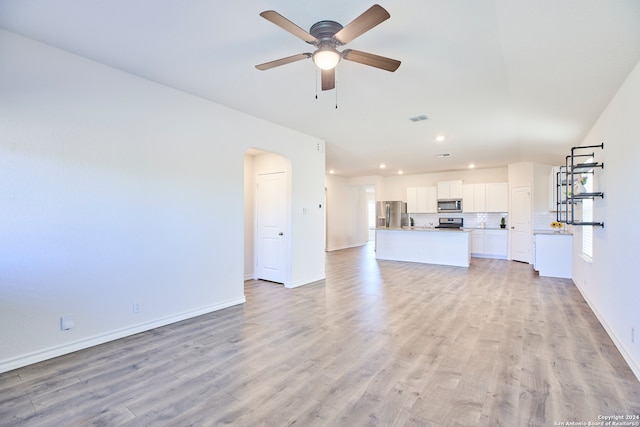 unfurnished living room featuring ceiling fan and light hardwood / wood-style floors