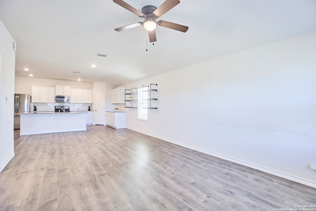 unfurnished living room with vaulted ceiling, light hardwood / wood-style flooring, and ceiling fan