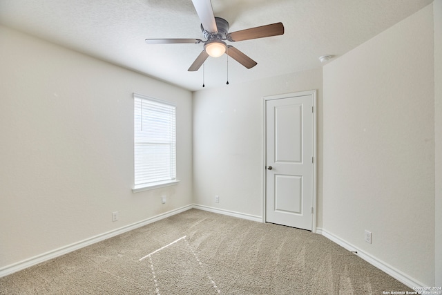 carpeted spare room with ceiling fan