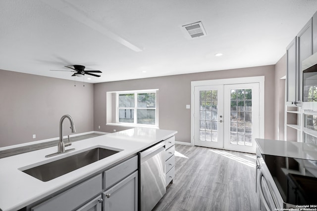 kitchen featuring gray cabinetry, dishwasher, french doors, sink, and light hardwood / wood-style flooring