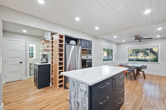 kitchen with ceiling fan, light hardwood / wood-style flooring, wooden ceiling, beamed ceiling, and a kitchen island