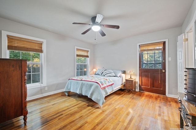 bedroom featuring ceiling fan, light wood-type flooring, and multiple windows