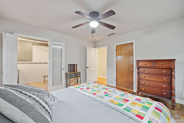 bedroom featuring hardwood / wood-style floors, ceiling fan, and ensuite bathroom