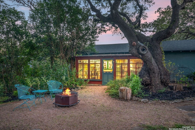 back house at dusk with an outdoor fire pit