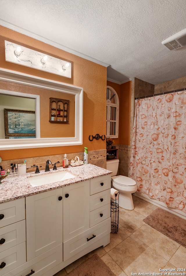 bathroom featuring a shower with shower curtain, tile patterned floors, vanity, a textured ceiling, and toilet