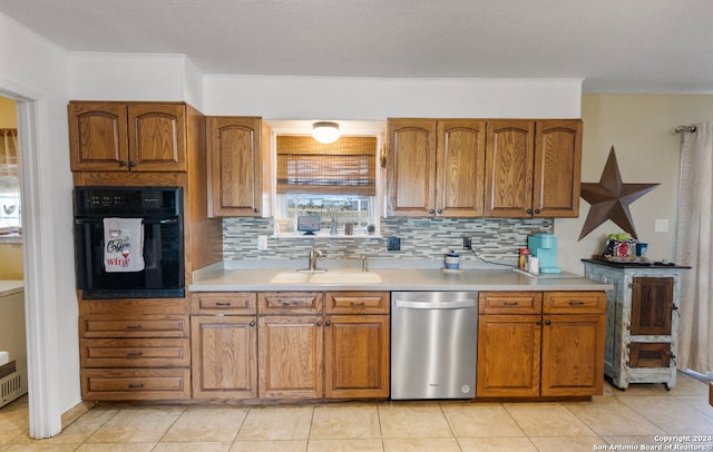 kitchen featuring backsplash, black oven, sink, and stainless steel dishwasher