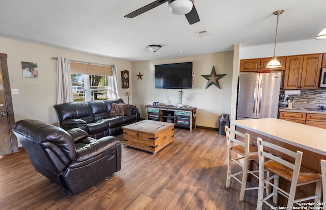 living room featuring ceiling fan and dark hardwood / wood-style flooring