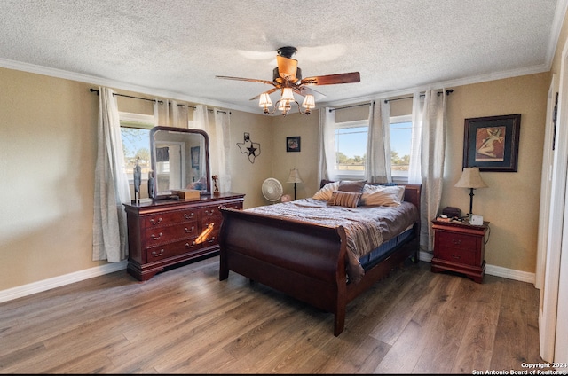 bedroom with ceiling fan, dark hardwood / wood-style flooring, crown molding, and a textured ceiling