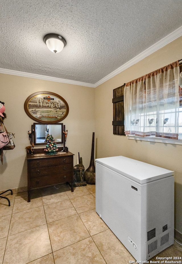 laundry room featuring a textured ceiling, ornamental molding, and light tile patterned flooring