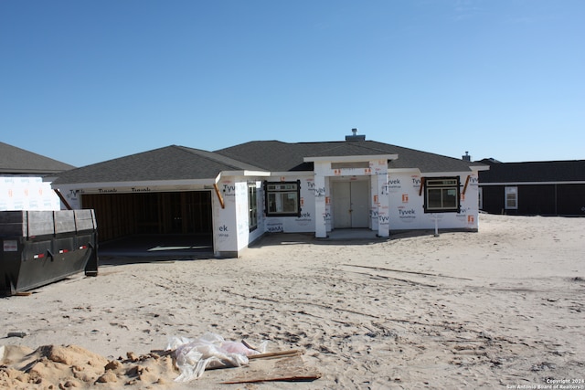 property in mid-construction featuring an attached garage and roof with shingles