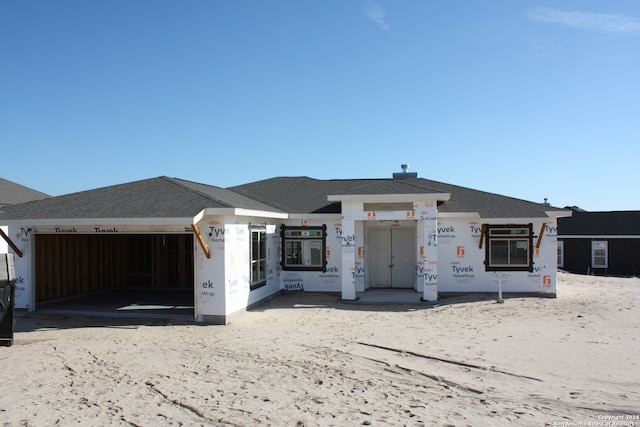 property under construction with a garage and roof with shingles