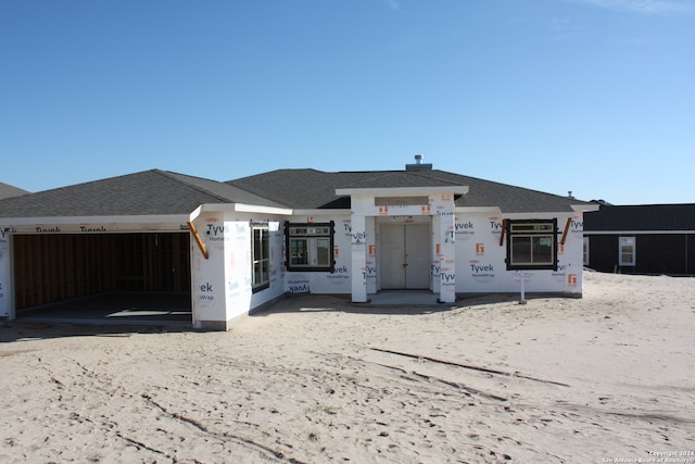 property under construction featuring an attached garage and a shingled roof