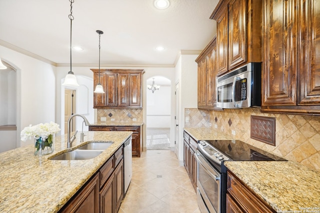 kitchen featuring light stone countertops, stainless steel appliances, sink, decorative light fixtures, and an inviting chandelier