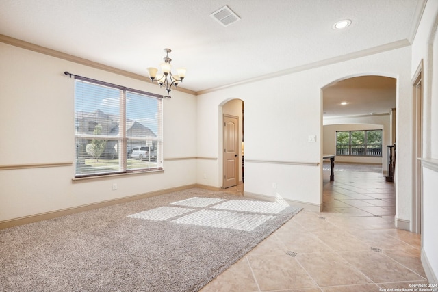 tiled spare room featuring a chandelier, a textured ceiling, and ornamental molding